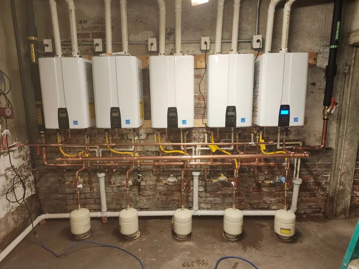 Bank of five tankless water heaters with copper piping installed by Elite Plumbing and Sewer